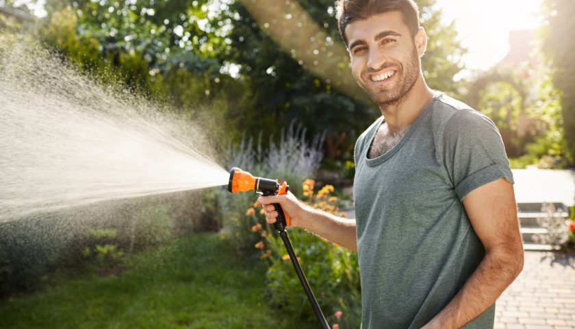 Mężczyzna podlewający ogród wodą ze studni